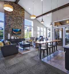 A modern open plan living and dining area with a stone wall and a television.
