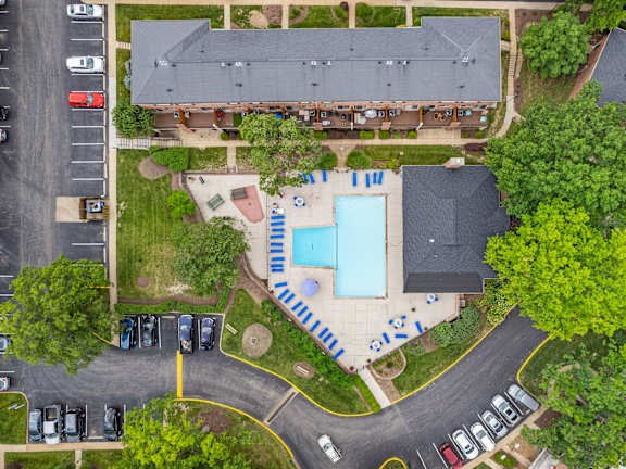 an overhead view of a building with a swimming pool