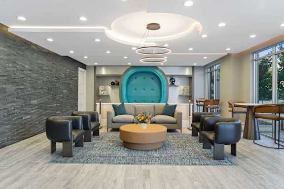 A modern living room with a large blue sofa and a wooden coffee table.