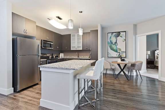 A modern kitchen with a dining table and chairs.