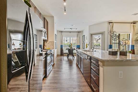 A kitchen with a refrigerator and a counter.