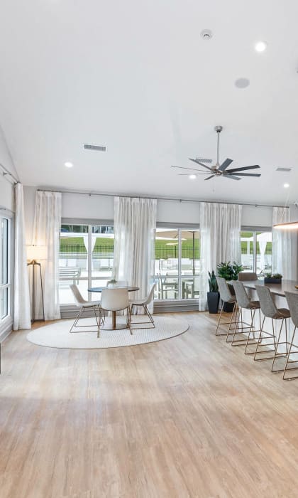 a living room with a kitchen and a bar with chairs