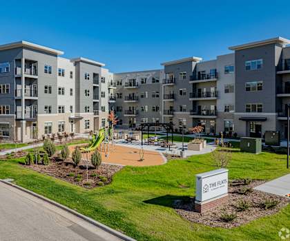 Apartment complex named The Flats with a playground in front.