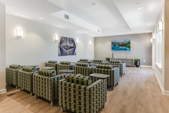 a room with a bunch of chairs and paintings on the wall
