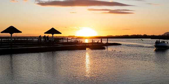 A serene sunset view with a dock and boats.