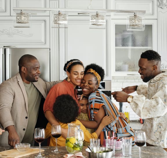 a group of people are gathered around a kitchen table