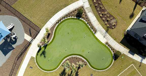 A large green space with a winding path and a few trees at Evolve St. James Apartment Homes Apartments, Southport, NC, 28461