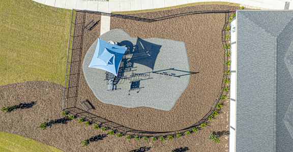 A playground with a slide and a swing set at Evolve St. James Apartment Homes Apartments, Southport, NC, 28461