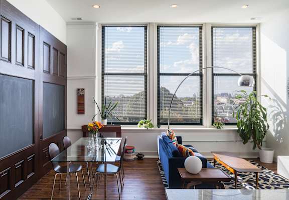 A modern living room with a glass table and a view of the city.