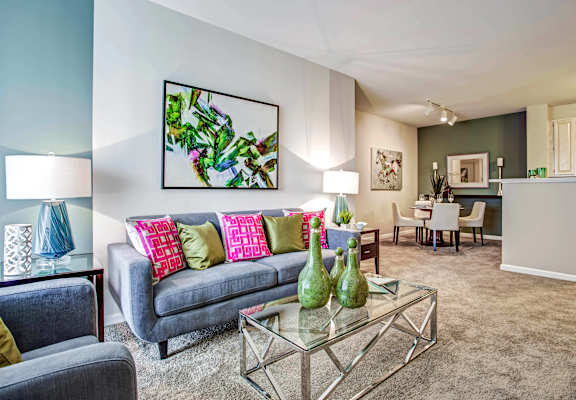 A living room with a grey couch and a glass coffee table at Amhurst Lake Apartments, Waukegan, IL, 60085