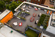 A rooftop patio with tables and chairs.