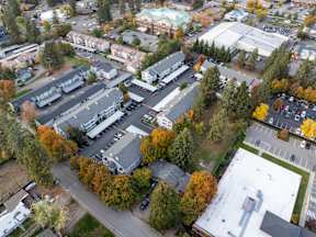 An aerial view of a parking lot and buildings surrounded by trees. at Ironwood Apartments, Coeur dAlene, ID, 83814