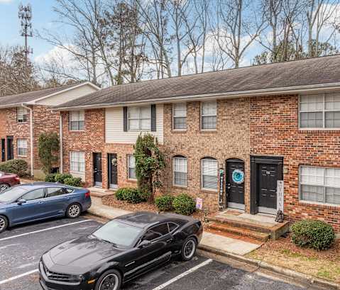 a brick house with cars parked in front of it