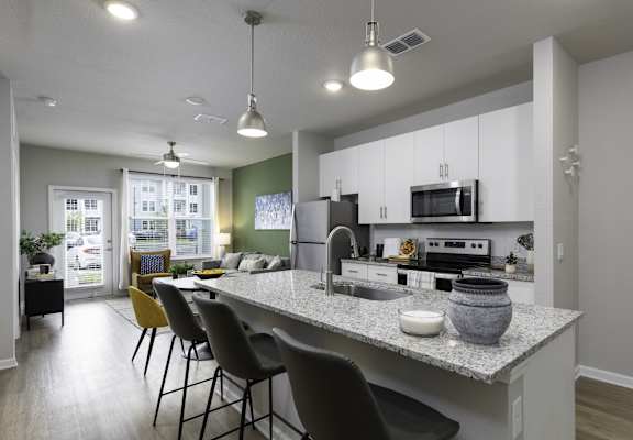 an open kitchen and living room with a granite counter top