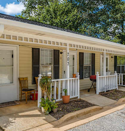 A small house with a porch and a white door.