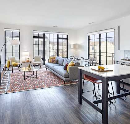 a living room with a couch and a table     and a kitchen