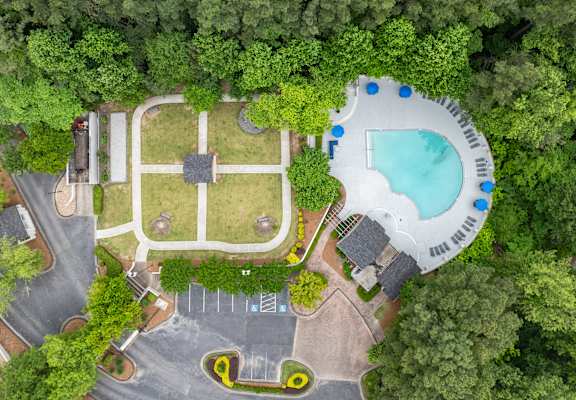 an overhead view of a yard with a pool and a backyard with trees