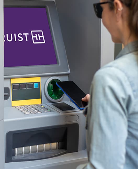 A person is using a bus ticket machine.
