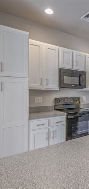 a kitchen with white cabinets and a black stove and refrigerator