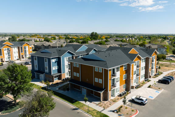 an aerial view of an apartment complex with a parking lot