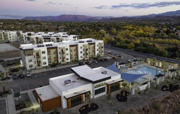an aerial view of a resort with a pool and buildings