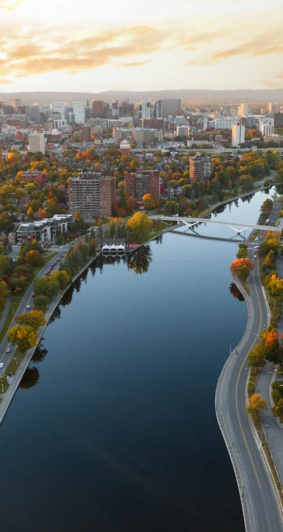 A river flows through a city with buildings on both sides. at Le Columbia Apartments , Quebec, J8Y 0A8