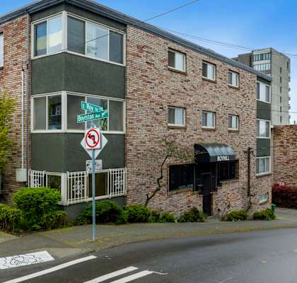 an apartment building on a street corner with a no left turn sign