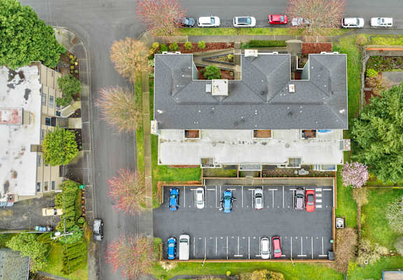 a birdseye view of a house and parking lot from above