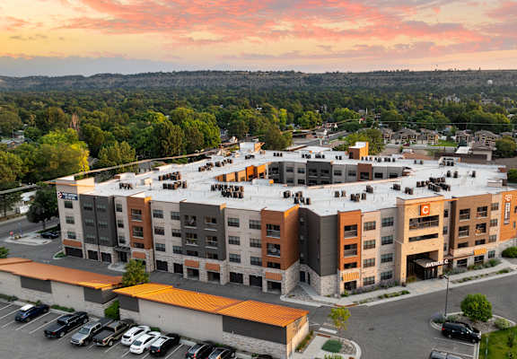 an aerial view of an apartment complex with a sunset in the background at Avenue C Apartments, Billings, MT, 59102