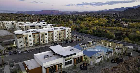 an aerial view of a resort with a pool and buildings