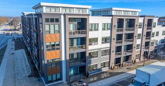 A modern multi-story building with a mix of white and brown exterior walls.