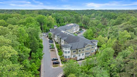 A bird's eye view of a large building surrounded by trees.