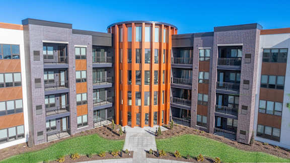 A modern building with a circular orange section in the middle.