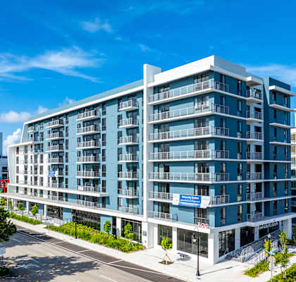 A modern multi-story building with a blue sky in the background.
