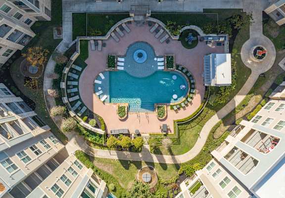 An aerial view of a pool surrounded by buildings.