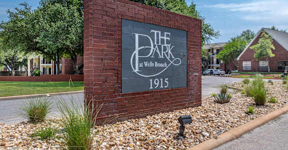 A sign for The Dark at Wells Branch with the year 1915 on it.