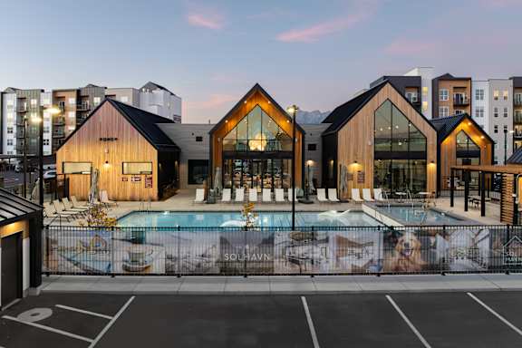 A modern building with a pool in front of it at Solhavn Apartments, American Fork, UT