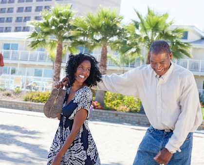 A man and a woman are walking together on a sunny day.