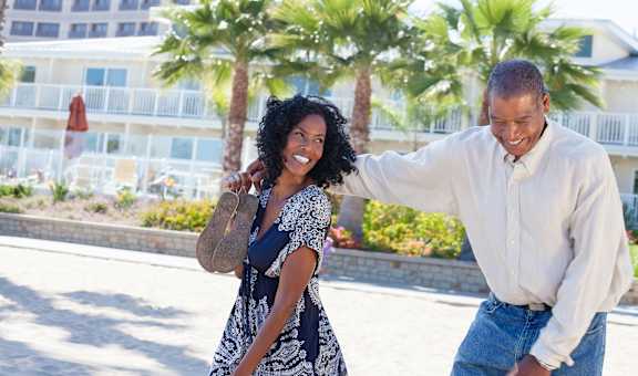 A man and a woman are walking together on a sunny day.