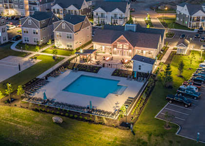 an aerial view of a swimming pool at night in front of a house at The Bend, Lancaster, OH