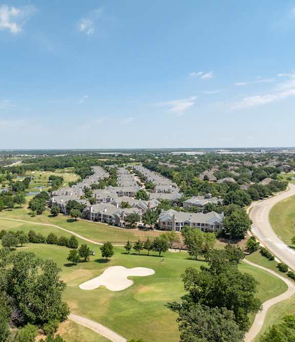 A golf course with a large building in the background.