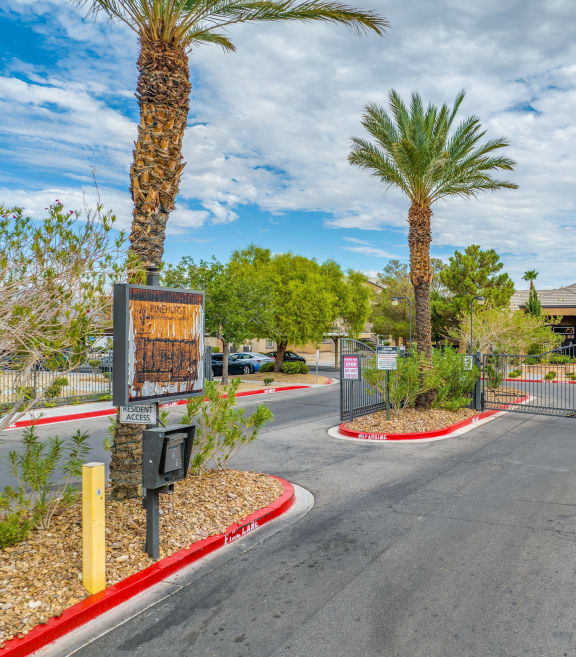 the entrance to a parking lot with palm trees