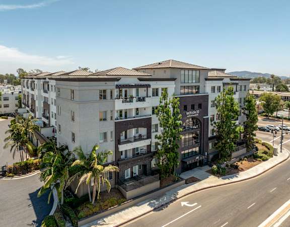 A modern apartment complex with a clear blue sky above.