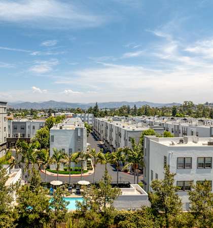 A view of apartment buildings with a pool in the foreground.
