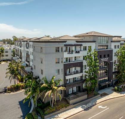 A modern apartment complex with a clear blue sky above.