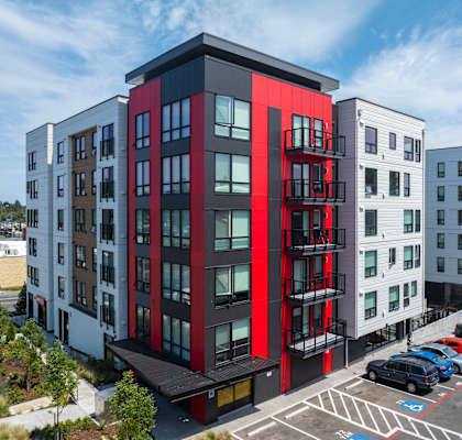 A modern multi-story building with a red and black exterior.