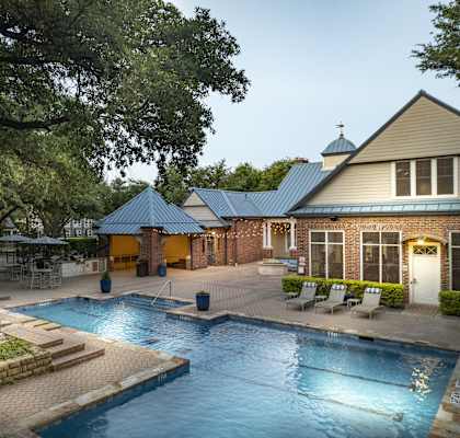 a swimming pool in front of a house with a resort style pool
