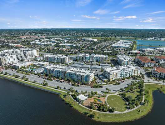 A bird's eye view of a residential area with a body of water in the foreground.