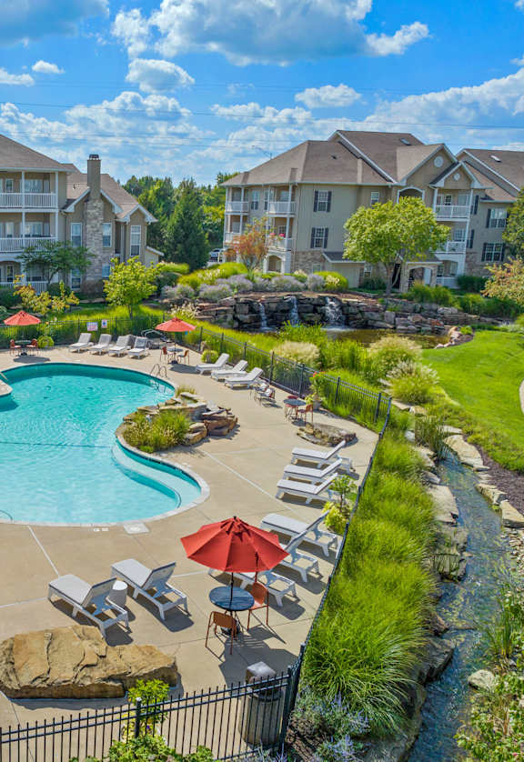 an aerial view of the resort style pool with lounge chairs and umbrellas