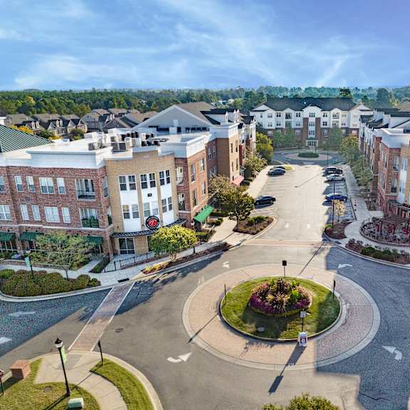 A roundabout in a residential area with apartment buildings on either side.